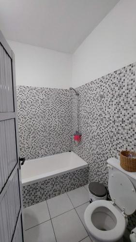 a bathroom with a bath tub and a toilet at Noche Hermosa in Chilecito