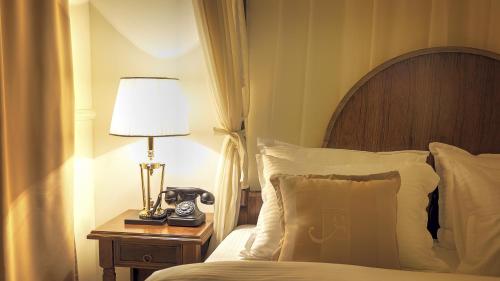 a bedroom with a bed with a phone on a night stand at Hotel Garden in Pristina