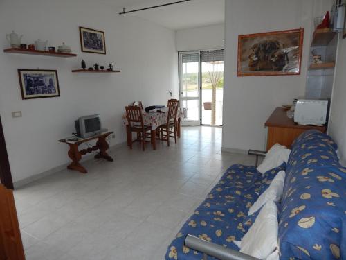 Un dormitorio con una cama y una mesa y sillas. en Otranto Green House, en Otranto
