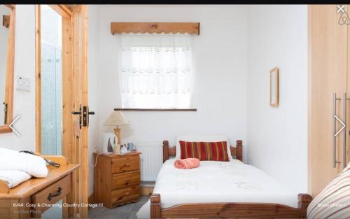 a small bedroom with a bed and a window at Toomullin House Accommodation in Doolin