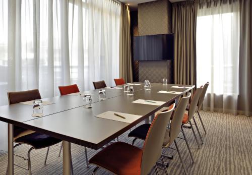 a conference room with a long table and chairs at Mercure Clermont Ferrand centre Jaude in Clermont-Ferrand