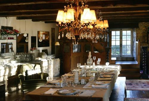 une salle à manger avec une grande table et un lustre dans l'établissement Maison d'Hôtes La Singulière, à Sévérac-le-Château