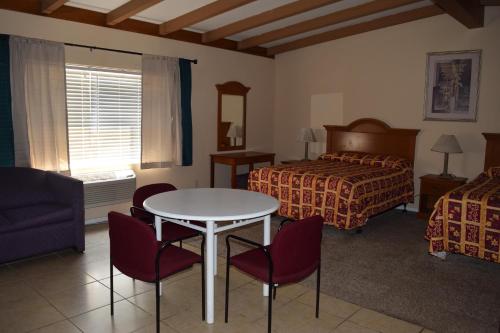a hotel room with a bed and a table and chairs at BUTTERFIELD STAGE MOTEL in Deming