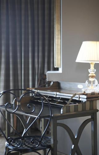 a table with a lamp and a chair next to a desk at Aegli Arachova in Arachova