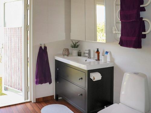 La salle de bains est pourvue d'un lavabo et de toilettes. dans l'établissement Holiday home MELLBYSTRAND X, à Mellbystrand