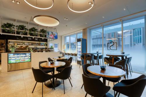 a restaurant with tables and chairs and a bar at Wyndham Garden Christchurch Kilmore Street in Christchurch