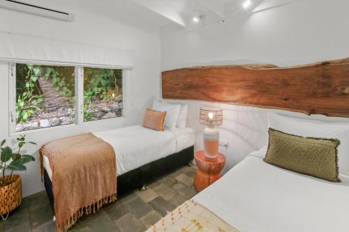 a bedroom with two beds and two windows at Serenity by the Sea in East Trinity