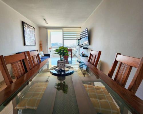 a dining room with a glass table with a plant on it at Departamento familiar en plan de Viña del Mar in Viña del Mar