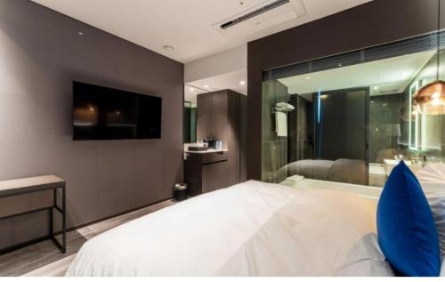a bedroom with a bed and a tv and a tub at Hotel SoulHada in Incheon