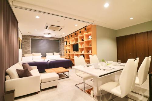 札幌的住宿－TAKETO STAY TERRACE ONE，一间设有白色桌子和白色椅子的用餐室