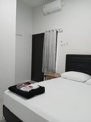 um quarto com uma cama branca e uma janela em Srikandi Baru Inn Blok O em Bantul