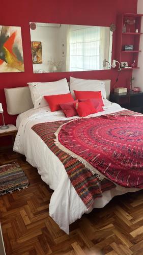 1 dormitorio con 1 cama grande y paredes rojas en ZEN Home en Tandil
