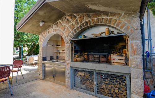 an outdoor kitchen with a stone wall at Pet Friendly Apartment in Starigrad-Paklenica