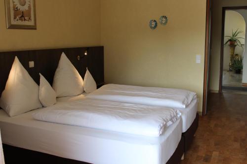 a bedroom with a bed with white sheets and pillows at Hotel Gasthof Rössle in Rottenburg