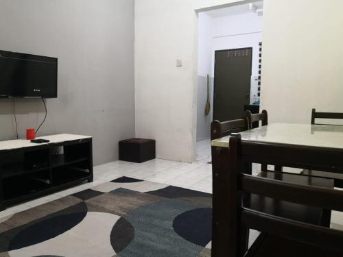 a living room with a table and a tv and a room at Cottage Garden in Penampang