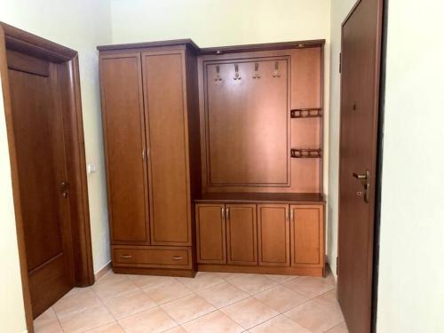 a kitchen with wooden cabinets and a tiled floor at Family friendly 2-bedroom apartment in Durres :) in Durrës