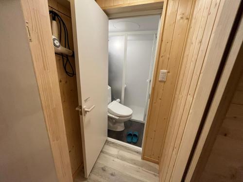 ein kleines Bad mit WC und Tür in der Unterkunft まめ庵 in Tamba