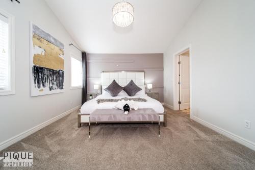 Una cama o camas en una habitación de LUXURIOUS 6 Bed Home I Fireplace I near Sports Park I with Double Garage & Fast WiFi!