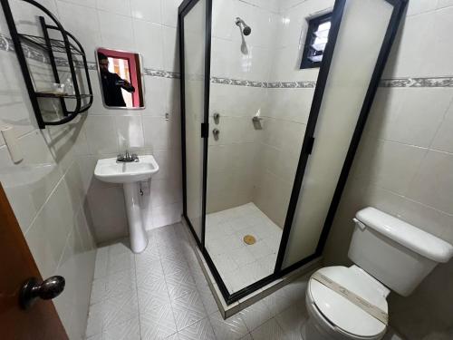 a bathroom with a shower and a toilet and a sink at Hotel Tres Flores in Huasca de Ocampo