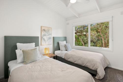 Säng eller sängar i ett rum på Biddles Beach House