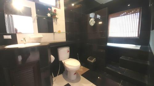 a bathroom with a white toilet and two sinks at Samui Diving Resort in Bophut