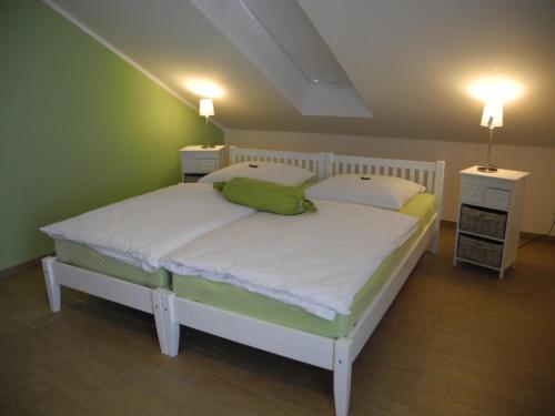 Un dormitorio con una cama grande con dos mesitas de noche. en SEASIDE APARTMENTS - MOSSY GREEN, en Eckernförde