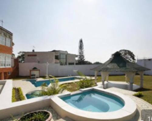 a swimming pool in a yard with a gazebo at Hostal Mallorca Boutique in Cali