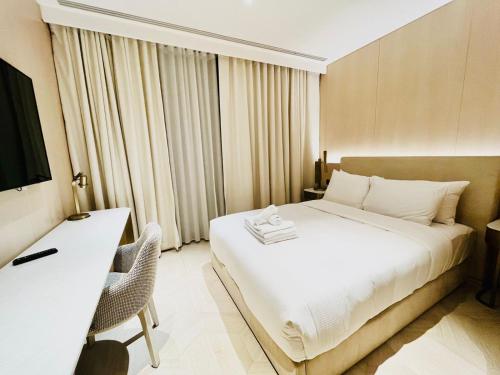 a bedroom with a bed and a desk and a television at FIVE Palm Jumeirah - 2 Bedrooms & Maid Room Apartment in a Splendid Resort in Dubai