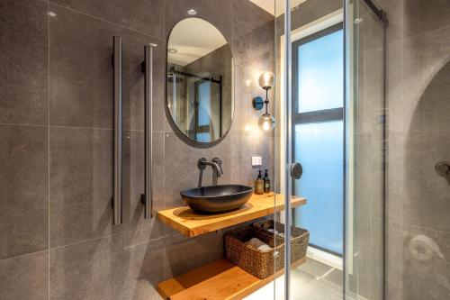 a bathroom with a sink and a mirror at Kaitiaki Lodge - Private pool & Spa in Putiki