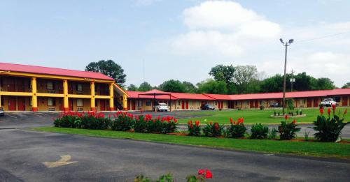 a building with red roofs and flowers in front of it at Duffys Motel - Calhoun in Calhoun