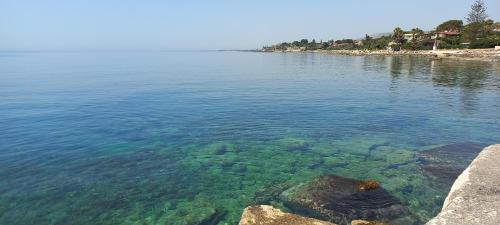 a view of a body of water with rocks at Appartamentino in villa a 2 passi dal mare in Fontane Bianche