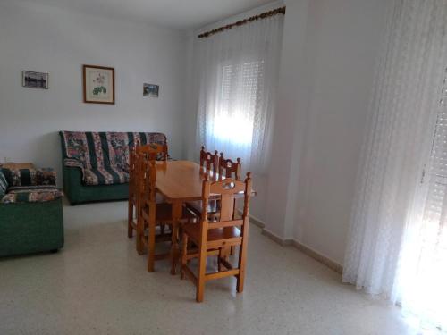 sala de estar con mesa, sillas y sofá en Pisos Isla Cristina 2, en Isla Cristina