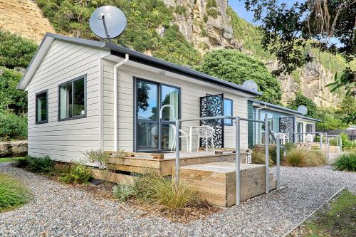 a tiny house with a hill in the background at Punakaiki Beachfront Motels in Punakaiki