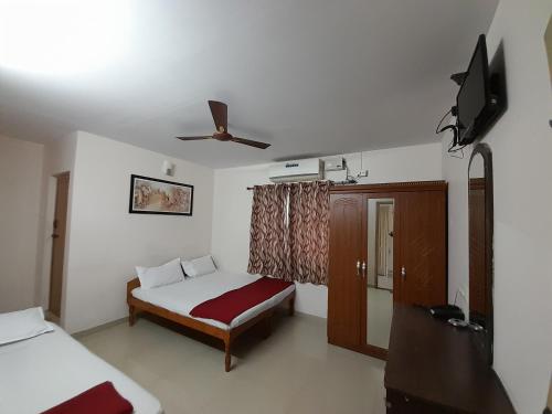 a bedroom with a bed and a ceiling fan at SUPREME RESIDENCY in Coimbatore