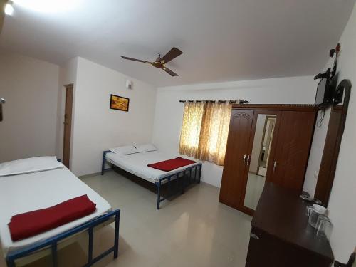 a bedroom with two beds and a ceiling fan at SUPREME RESIDENCY in Coimbatore