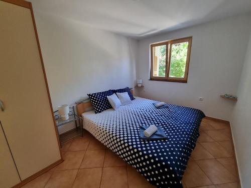 a bedroom with a bed with blue and white sheets at Apartments Casia in Baška