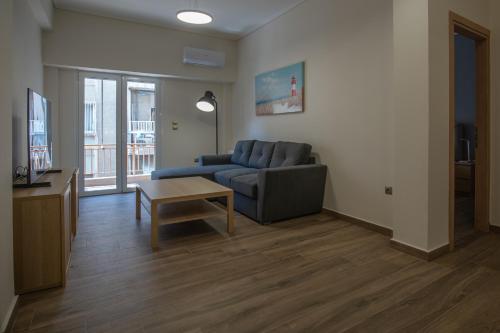 ein Wohnzimmer mit einem Sofa und einem Tisch in der Unterkunft Max Blue apartment, a stay like no other in Piräus