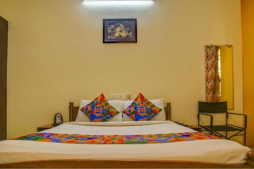 a bedroom with a large bed with colorful pillows at FabHotel Hibiscus Stays in Chennai