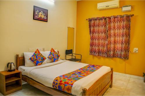 una camera da letto con un grande letto con cuscini colorati di FabHotel Hibiscus Stays a Chennai