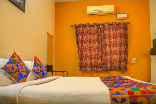 a bedroom with a bed and a window at FabHotel Hibiscus Stays in Chennai
