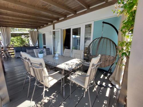 a patio with a table and chairs on a deck at Holiday Homes Lavanda - Camping Park Soline, Biograd na Moru in Biograd na Moru