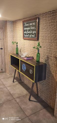 a table with two green bottles on a wall at Backpack Stay in Mumbai