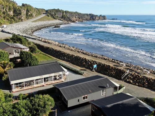 an aerial view of a house and the ocean at Punakaiki Beachfront Motels in Punakaiki