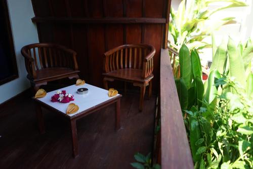 2 sedie e un tavolo su un portico di Gili Mesari Cottages & Homestay a Gili Trawangan