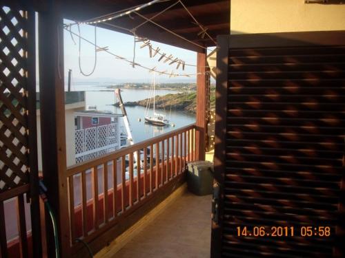 a balcony with a view of a boat in the water at Stella Marina in Stintino