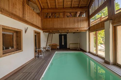 - une piscine intérieure dans une maison dotée d'un plafond en bois dans l'établissement Ferme de Faustine 2 - piscine, à Saint-Gervais-les-Bains