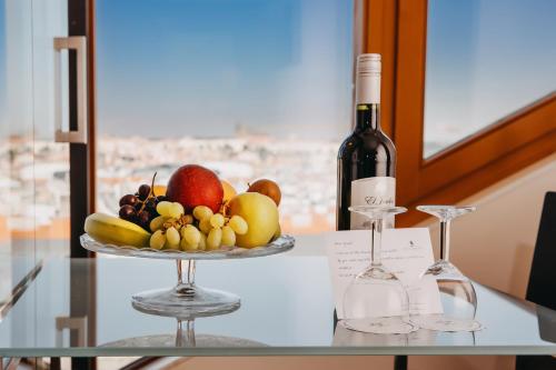 un plato de fruta en una mesa con una botella de vino en Wenceslas Square Hotel - Czech Leading Hotels en Praga