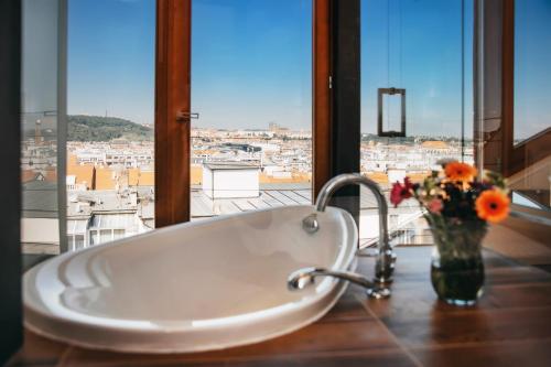 a bathroom with a tub with a vase of flowers at Wenceslas Square Hotel - Czech Leading Hotels in Prague