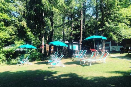 a group of chairs and umbrellas in a yard at Campeggio il Bosco in Entracque