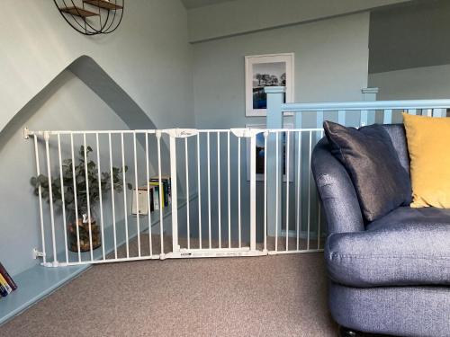a crib in a room with a couch and a chair at The Wild Daisy in Barnoldswick